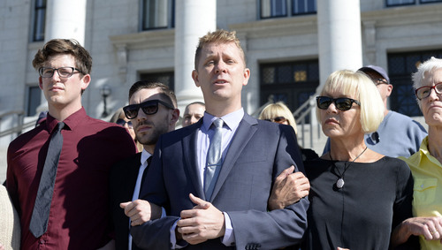Al Hartmann  |  The Salt Lake Tribune
LGBT protesters known as the "Capitol 13" stand arm in arm in front of the Utah Capitol building with their lawyers Thursday August 28, 2014, to collectively announce their not guilty plea. They were arrested at the Legislature in February for disturbing a meeting, a class B misdemeanor, but were just charged Wednesday.