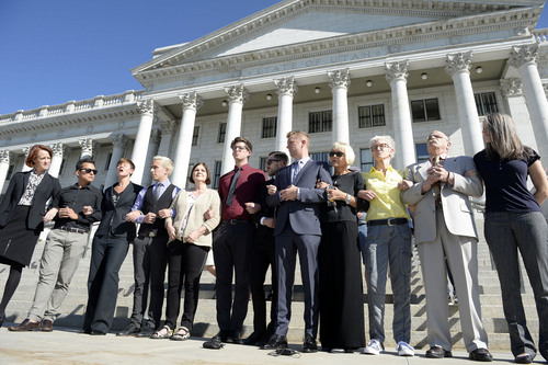 Al Hartmann  |  The Salt Lake Tribune
LGBT protesters known as the "Capitol 13" stand arm in arm in front of the Utah Capitol building with their lawyers Thursday August 28, 2014, to collectively announce their not guilty plea.  They were arrested at the Legislature in February for disturbing a meeting, a class B misdemeanor, but were just charged Wednesday.