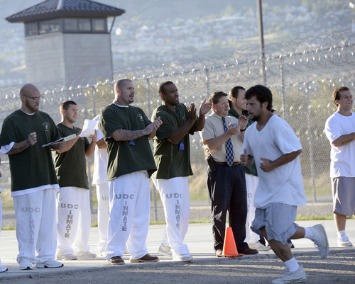 Al Hartmann  |  The Salt Lake Tribune
Inmates and prison staff cheer on and time 43 male inmates in the Con-Quest substance abuse program run in the first 5K race at the Utah State Prison Thursday August 28, 2014.  They ran 16 laps around the fenced jogging track made muddy from recent rain.  The 5K was a first for most inmates, who have been training in anticipation of the race and in line with the prison's Addict II Athlete program.