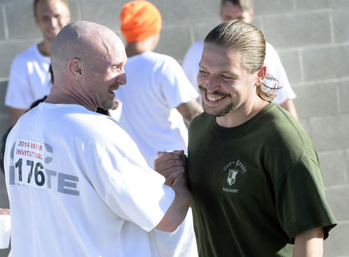 Al Hartmann  |  The Salt Lake Tribune
Kurtis Hunsaker, right, gets congratulations from a fellow inmate in winning the first 5K race at the Utah State Prison on Thursday, with a time of 22:05. Forty-three inmates ran 16 laps around the fenced jogging track made muddy from recent rain. The 5K was a first for most inmates, who have been training in anticipation of the race and in line with the prison's Addict II Athlete program.