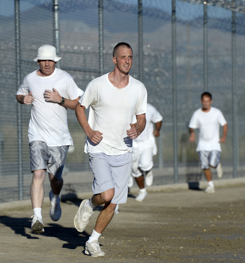 Al Hartmann  |  The Salt Lake Tribune
Forty-three male inmates in the Con-Quest substance abuse program run in the first 5K race at the Utah State Prison Thursday August 28, 2014.  They ran 16 laps around the fenced jogging track made muddy from recent rain.  The 5K was a first for most inmates, who have been training in anticipation of the race and in line with the prison's Addict II Athlete program.