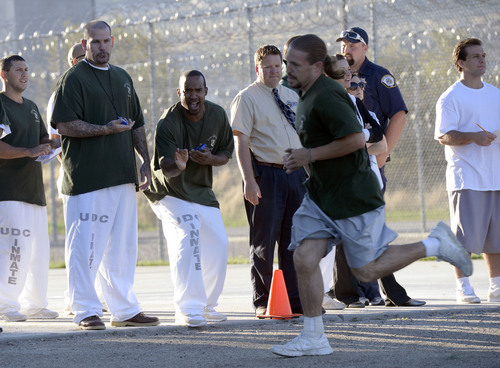 Al Hartmann  |  The Salt Lake Tribune
Inmates and prison staff cheer on and time 43 male inmates in the Con-Quest substance abuse program run in the first 5K race at the Utah State Prison Thursday August 28, 2014.  They ran 16 laps around the fenced jogging track made muddy from recent rain.  The 5K was a first for most inmates, who have been training in anticipation of the race and in line with the prison's Addict II Athlete program.