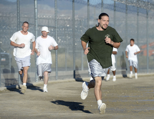 Al Hartmann  |  The Salt Lake Tribune
Forty-three male inmates in the Con-Quest substance abuse program run in the first 5K race at the Utah State Prison Thursday August 28, 2014.  They ran 16 laps around the fenced in jogging track made muddy from recent rain.  The 5K was a first for most inmates, who have been training in anticipation of the race and in line with the prison's Addict II Athlete program.