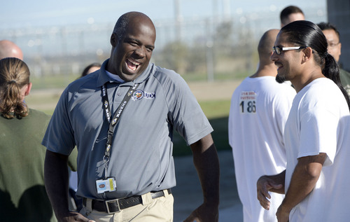 Al Hartmann  |  The Salt Lake Tribune
Desmond Lomax, clinincal supervisor-program director at the prison's Con-Quest Program, left, congratulates 43 inmates who ran the first 5K race at the Utah State Prison on Thursday. Inmates ran 16 laps around the fenced jogging track made muddy from recent rain. The 5K was a first for most inmates, who have been training in anticipation of the race and in line with the prison's Addict II Athlete program.