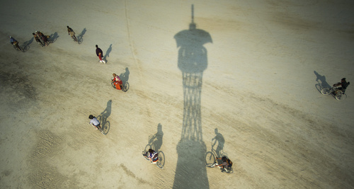 Rick Egan  |  The Salt Lake Tribune

Cyclists ride past the shadow of the Cosmic Praise tower at the Burning Man festival in the Black Rock Desert, north of Reno, Friday, August 29, 2014.