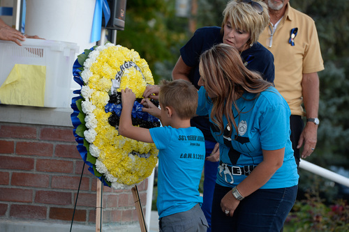 Francisco Kjolseth  |  The Salt Lake Tribune
Shanté Johnson and her son Benson, 7, place carnations on a wreath during memorial service at the Draper Historic Park on Labor Day marking the one-year anniversary of Draper police Sgt. Derek Johnson's death.
