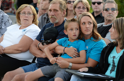 Francisco Kjolseth  |  The Salt Lake Tribune
ShantÈ Johnson embraces her son Benson, 7, as they look up to see the fly over by Life Flight during a memorial service marking the one-year anniversary of Draper police Sgt. Derek Johnson's death at the Draper Historic Park on Labor Day.