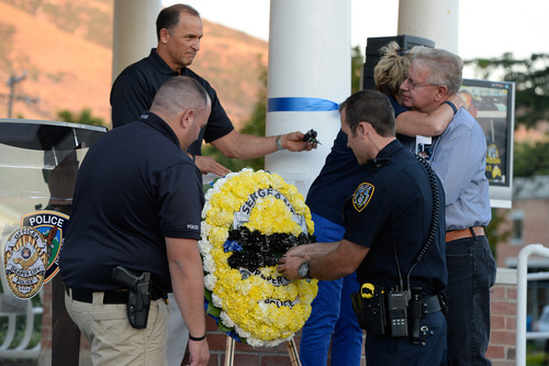 Francisco Kjolseth  |  The Salt Lake Tribune
Draper police officers place black carnations on a wreath in honor of Sgt. Derek Johnson during memorial services marking the one-year anniversary of his death in the line of duty at the Draper Historic Park on Labor Day.