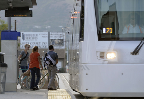 Al Hartmann  |  The Salt Lake Tribune 
Folks climb aboard the Sugar House streetcar at the 900 East stop Wednesday August 13, 2014.  It is only slightly faster than the nearby parallel bus, and pedestrians sometimes can outrace it. Far fewer people than projected are riding it. And it was expensive, $37 million. But officials still see it as a success and worth the price because of the economic development it has attracted.