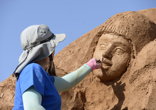 Al Hartmann  |  The Salt Lake Tribune
Karen Frailich of Sandscapes starts the first face of sand in a large sculpture to be worked on througout the week of the Utah State Fair, which opens Thursday. It will have a parent and family empowerment theme in sculpting an alcohol-free future.
