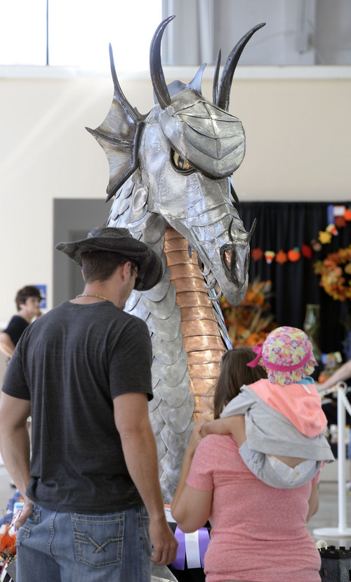 Al Hartmann  |  The Salt Lake Tribune
The Utah State Fair opens Thursday September 4, 2014. A fairgoer takes in a metal sculpture dragon by Richard Prazen.  It won Best of Show in the Creative Arts Division.