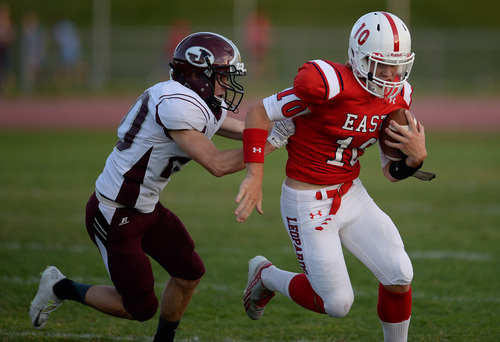 Francisco Kjolseth  |  The Salt Lake Tribune
East High's Cole Peterson tries to stay ahead of Jordan in game action on Friday, Aug. 29, 2014, at East.