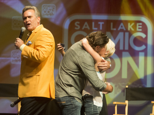 Rick Egan  |  The Salt Lake Tribune

Jarrod Phillips hugs his girlfriend, Melissa Johnson, as Bruce Campbell talks to the crowd, after Phillips proposed to Johnson, during Comic Con, at the Salt Palace, Friday, September 5, 2014.