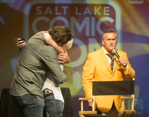 Rick Egan  |  The Salt Lake Tribune

Jarrod Phillips hugs his girlfriend, Melissa Johnson, as Bruce Campbell talks to the crowd, after Phillips proposed to Johnson, during Comic Con, at the Salt Palace, Friday, September 5, 2014