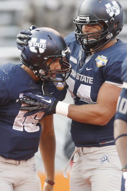 Chris Detrick  |  The Salt Lake Tribune
Utah State Aggies offensive linesman Kevin Whimpey (74) celebrates a touchdown by quarterback Chuckie Keeton (16) during the first quarter of the Famous Idaho Potato Bowl at Bronco Stadium Saturday December 15, 2012.  At the end of the first quarter the Aggies were winning, 7-3.