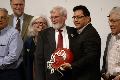 Al Hartmann  |  The Salt Lake Tribune
David W. Pershing, University of Utah president, center and Gordon Howell, chairman of the Ute Indian Tribe Business Committee pose for a photo with a Ute football helmet after signing a memorandum of understanding outlining the University's continued use of the Ute name for its athletics teams at a ceremony at Fort Duchesne Tuesday April 15.