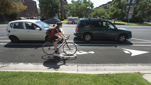 Steve Griffin  |  The Salt Lake Tribune


A cyclist travels in the bike lane between the curb and parked cars on 300 South near 300 east in Salt Lake City, Friday, August 29, 2014.  Protected bike lanes from 600 East to 300 West will require the loss of about one-third of curbside parking because angle parking will change to parallel parking to make room for the bike lanes.