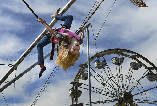 Scott Sommerdorf   |  The Salt Lake Tribune
Katie Park, 10, flips during her ride on the "Power Jump" during the final day of the Utah State Fair, Sunday, September 14, 2014.