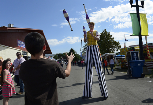 Scott Sommerdorf   |  The Salt Lake Tribune
"Leapin' Louie" juggles with a young fair visitor during the final day of the Utah State Fair, Sunday, September 14, 2014.