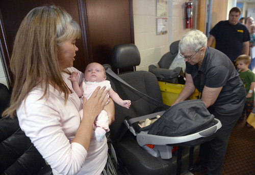 Al Hartmann  |  The Salt Lake Tribune
Stephanie Sedgley with 5-week-old Kendallyn get an infant car seat at the Road Home shelter Monday September  15.  Salt Lake County Health Dept. health advisor Carol Avery, right, explains how to set up the seat correctly.