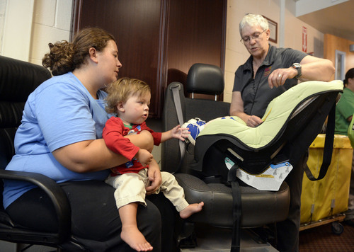 Al Hartmann  |  The Salt Lake Tribune
Michelle Vickers, and son one-year-old son Liam get set up with a child's car seat at the Road Home shelter Monday September  15.  Salt Lake County Health Dept. health advisor Carol Avery, right, explains how to set up the seat correctly.