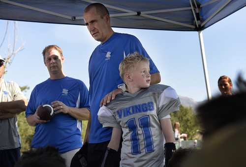 Scott Sommerdorf   |  The Salt Lake Tribune
Brandon Doman, former BYU offensive coordinator, with his son Jace Doman as he talks to the team after it's first loss of the season. Doman coaches the fourth-grade football team - The  Pleasant Grove Vikings, Saturday, September 13, 2014.