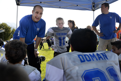 Scott Sommerdorf   |  The Salt Lake Tribune
Brandon Doman, former BYU offensive coordinator, speaks to his team - The Pleasant Grove Vikings - after a loss to American Fork, Saturday, September 13, 2014. At center is his son, Jace Doman, and another son, Isaac, is at right, in foreground, listening to Doman go over things they did well, and things they could have done better.