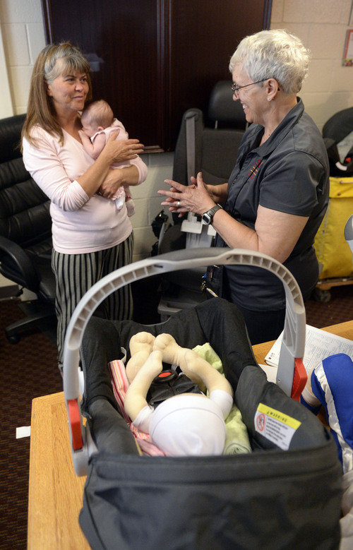 Al Hartmann  |  The Salt Lake Tribune
Stephanie Sedgley with 5-week-old Kendallyn get an infant car seat at the Road Home shelter Monday September  15.  Salt Lake County Health Dept. health advisor Carol Avery, right, explains how to set up the seat correctly.