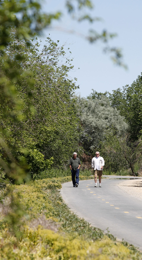 Al Hartmann  |  The Salt Lake Tribune 
Walkers stroll along a newly opened section of the Jordan River Parkway Trail, running from about 1800 North in Salt Lake City to the Davis County line. The trail connects to the Legacy Parkway Trail.
