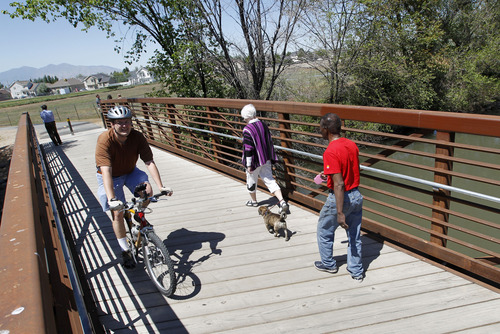 Al Hartmann  |  The Salt Lake Tribune 
Bicyclists and walkers cross the Jordan RIver on a bridge at 1800 N. Redwood Road to access one of the last sections of the Jordan River Parkway Trail be be completed. The new section opened Thursday extends one mile and connects Salt Lake and Davis counties. The stretch includes a 10-foot-wide asphalt trail, 5-foot-wide horse trail and 1,000 feet of elevated boardwalk through a wetlands area.