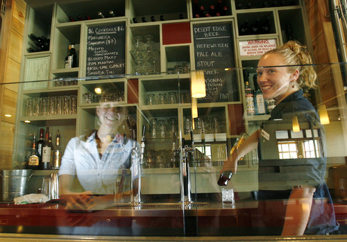 Tribune file photo
In this 2008 file photo, Stella Grill bartender Taylor Pape (right) makes a drink as manager Erin O'Conner sits at the counter and is reflected in the restaurant's  "Zion Curtain" which is a glass divider that separates the counter area from the bar area of the restauran.