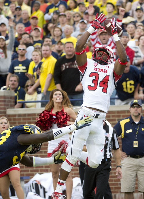 Jeremy Harmon  |  The Salt Lake Tribune

Utah's Bubba Poole (34)just misses the ball under pressure from Michigan's Mario Ojemudia (53) as the Utes face the Wolverines in Ann Arbor, Saturday, Sept. 20, 2014.