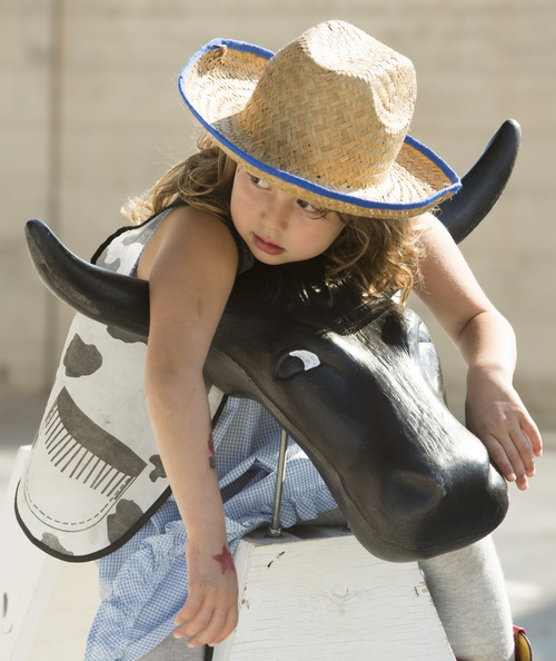 Rick Egan  |  The Salt Lake Tribune

Siena Slagle, 4, Salt Lake City, rests on a plastic bull, at the Natural History Museum of Utah during the Cowboy Festival and BBQ, Saturday, September 20, 2014.  As part of its special exhibit, The Horse, the Natural History Museum of Utah is hosting a Cowboy Festival and BBQ this weekend with Western-themed food and fun. The festival continues Sunday from 10 a.m. to 5 p.m, with a live barbecue, live music, cowboy poetry and hands-on activities for kids.