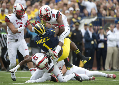 Jeremy Harmon  |  The Salt Lake Tribune

Utah's Brian Blechen (4), Eric Rowe (18) and Justin Thomas (12) tackle Michigan's Devin Funchess as the Utes face the Wolverines in Ann Arbor, Saturday, Sept. 20, 2014.