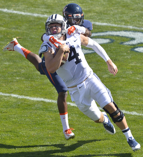 Chris Detrick  |  The Salt Lake Tribune
Brigham Young Cougars quarterback Taysom Hill (4) is tackled by Virginia Cavaliers safety Anthony Harris (8) during the game at LaVell Edwards Stadium Saturday September 20, 2014. No flag was thrown on the play. Virginia is winning the game 16-13 at halftime.