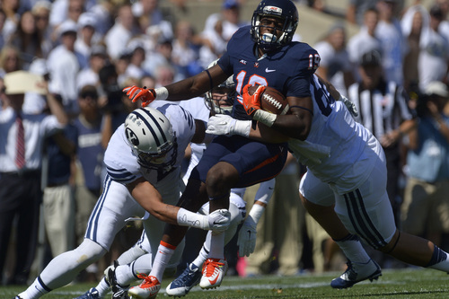 Chris Detrick  |  The Salt Lake Tribune
Virginia Cavaliers wide receiver Donovan Dowling (19) is tackled by Brigham Young Cougars linebacker Alani Fua (5) during the game at LaVell Edwards Stadium Saturday September 20, 2014.  Virginia is winning the game 16-13 at halftime.