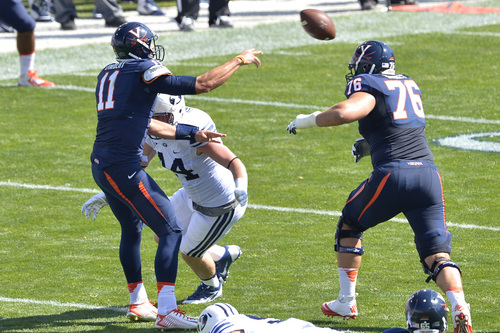 Chris Detrick  |  The Salt Lake Tribune
Virginia Cavaliers quarterback Greyson Lambert (11) throws the ball under pressure from Brigham Young Cougars defensive lineman Remington Peck (44) during the game at LaVell Edwards Stadium Saturday September 20, 2014.  Virginia is winning the game 16-13 at halftime.
