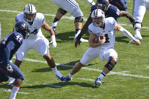 Chris Detrick  |  The Salt Lake Tribune
Brigham Young Cougars quarterback Taysom Hill (4) runs past Virginia Cavaliers linebacker Henry Coley (44) during the game at LaVell Edwards Stadium Saturday September 20, 2014.  Virginia is winning the game 16-13 at halftime.