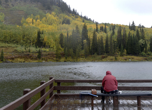 Al Hartmann  |  The Salt Lake Tribune
Fisherman braves a cold rain Sunday September 21 at Silver Lake in Big Cottonwood Canyon.  Fishing was slow but the fall colors made up for it.