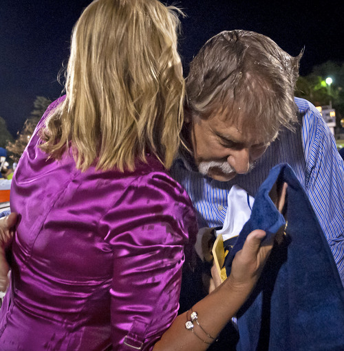 Michael Mangum  |  Special to The Salt Lake Tribune

KUTV 2News reporter Shauna Lake, left, and Tribune columnist Robert Kirby share a hug after Kirby had buckets of ice water dumped on him, one by Lake, as part of the ALS Ice Bucket Challenge during halftime of the Homecoming football game at Skyline High School on Friday, September 19, 2014.