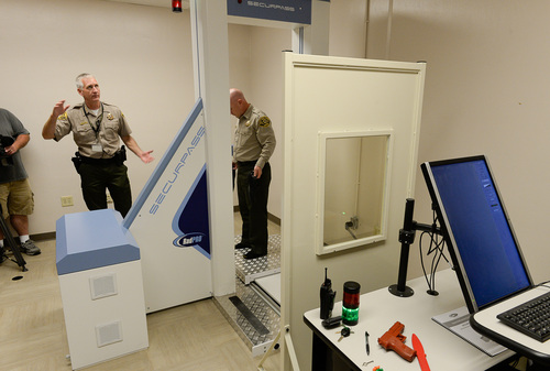 Francisco Kjolseth  |  The Salt Lake Tribune
Salt Lake County Sheriff Jim Winder, left, left talks about the new system to detect contraband as Lt. Dave Hall steps in to demonstrate. The SecurPASS Whole Body Contraband Detection System uses "transmission imaging" technology that is less intrusive because it does not show facial features or private body parts.