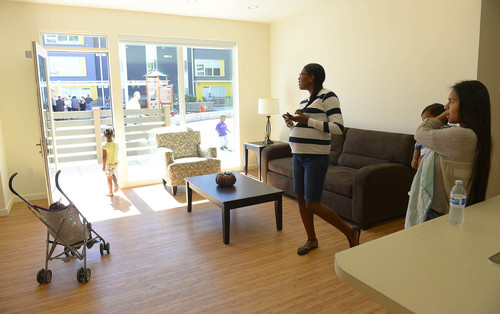 Leah Hogsten  |  The Salt Lake Tribune
Bud Bailey Apartment Complex residents Catalina Barrios, holding son Tyson Jr., (right) and Jasmine Louis compare the appliances and fixtures in the model apartment to their own. Salt Lake County and County Housing Authority officials dedicated 72 new housing units located at the Bud Bailey Apartment Complex, 3970 S. Main St., which are designed in part to provide housing for low-income and end chronic homelessness, Wednesday, Sept. 24, 2014.