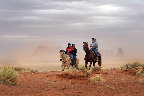 FILE In this Jan.e 30, 2014 file photo, Jaydon Yazzie, VanteJren Atene, and  McKalette Clark ride home from Monument Valley High School on their horses in Monument Valley, Utah.  The school, which has grades seven-12, must prepare its 216 students, who grow up amid the Navajo Nation's iconic red mesas, for success in the wider world: jobs, college, trade school, Anglo culture. The Navajo Nation is poised receive $554 million from the federal government over mismanagement of tribal resources in the largest settlement of its kind for a single Native American tribe.  (AP Photo/The Salt Lake Tribune, Rick Egan) DESERET NEWS OUT; LOCAL TV OUT; MAGS OUT