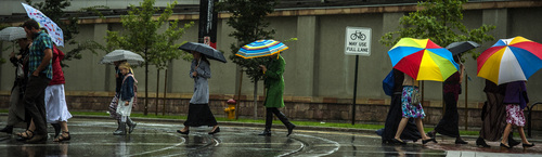 Chris Detrick  |  The Salt Lake Tribune
Pedestrians attempt to stay dry under umbrellas while crossing South Temple Street in Salt Lake City Saturday September 27, 2014.