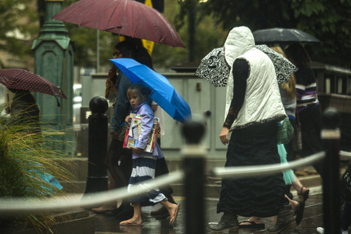 Chris Detrick  |  The Salt Lake Tribune
Pedestrians attempt to stay dry under umbrellas while crossing Main Street in Salt Lake City Saturday September 27, 2014.
