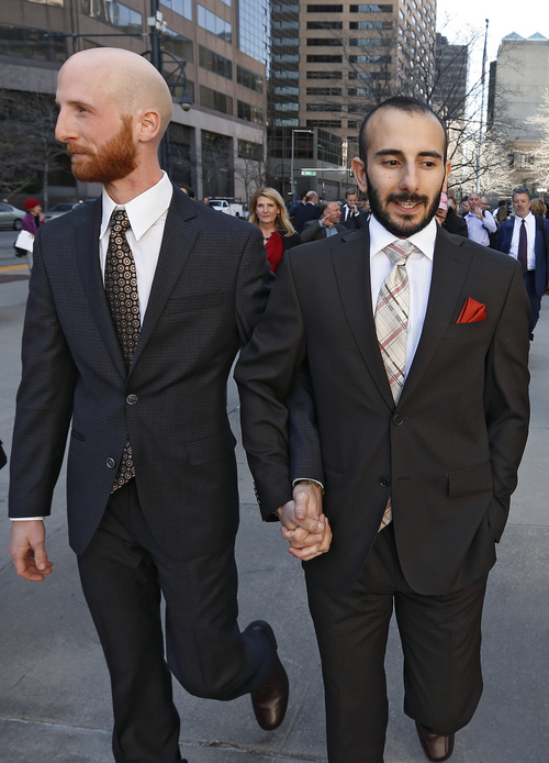 Plaintiffs challenging Utah's gay marriage ban Moudi Sbeity, right, and his partner Derek Kitchen, hold hands as they leave the courthouse following a hearing at the U.S. Circuit Court of Appeals in Denver, Thursday, April 10, 2014.  (AP Photo/Brennan Linsley)