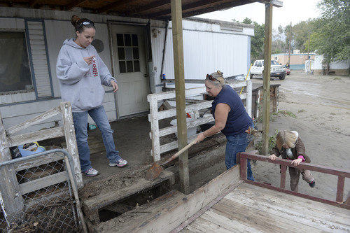 Al Hartmann  |  The Salt Lake Tribune
Daryl Parker and Denise Wilstead scrape mud from the front porch of their cousin's trailer Monday Sept. 29, 2014, at the Pilling Trailer Park in Carbonville near Price. Many trailers are unlivable from the flooding caused by the Price River overflowing its banks Saturday night. On Sunday most people at the park dug out what they could and removed belongings.