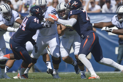 Chris Detrick  |  The Salt Lake Tribune
Brigham Young Cougars quarterback Taysom Hill (4) is tackled by Virginia Cavaliers linebacker Henry Coley (44) and Virginia Cavaliers defensive end Eli Harold (7) during the game at LaVell Edwards Stadium Saturday September 20, 2014.  Virginia is winning the game 16-13 at halftime.
