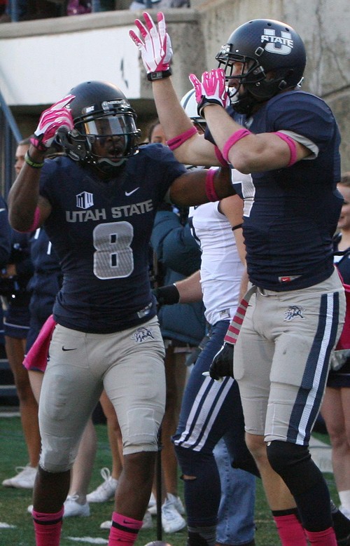 Leah Hogsten | The Salt Lake Tribune
Utah State Aggies wide receiver Travis Reynolds (8) celebrates teammate Utah State Aggies wide receiver Travis Van Leeuwen's (7) touchdown. Brigham Young University Cougars lead 10-7 after the first quarter during their matchup against  Utah State University Aggies  Friday, October 4, 2013 in Logan.