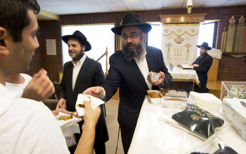 Steve Griffin  |  The Salt Lake Tribune
Rabbi Benny Zippel passes out honey cake to worshippers who ask for it, as part of a tradition on the eve of Yom Kippur, following Mincha (afternoon prayer) at the synagogue for Chabad Lubavitch of Utah in Salt Lake City Friday, October 3, 2014. The tradition preceded Friday night's Yom Kippur services at the synagogue. Yom Kippur is the holiest day of the Jewish calendar. The tradition of asking for honey cake is to circumvent any possible Heavenly decree that one should have to ask another for sustenance during the upcoming year.